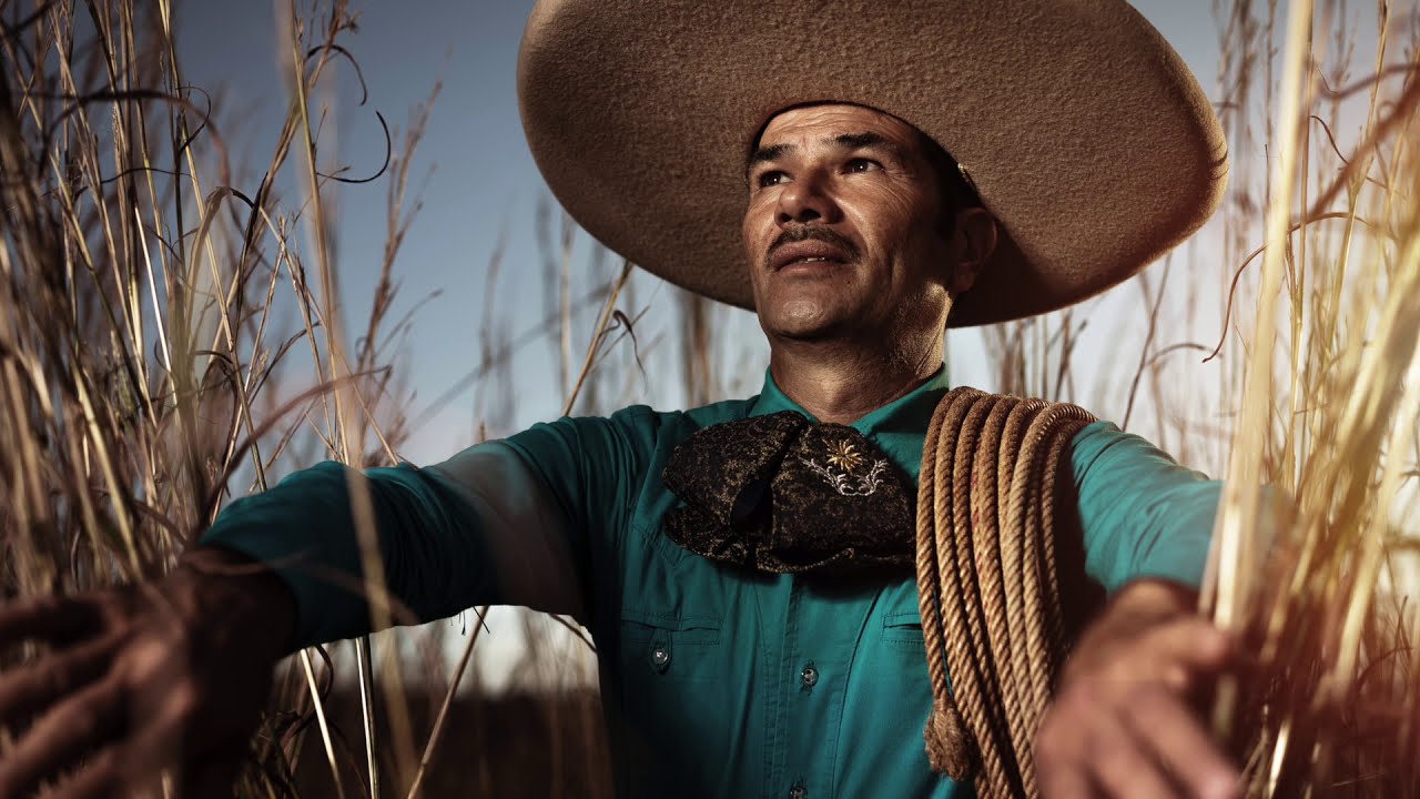 Charro with a coiled lasso standing in tall grass near Compostela, Mexico